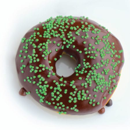 Donut with chocolate icing and green sprinkles