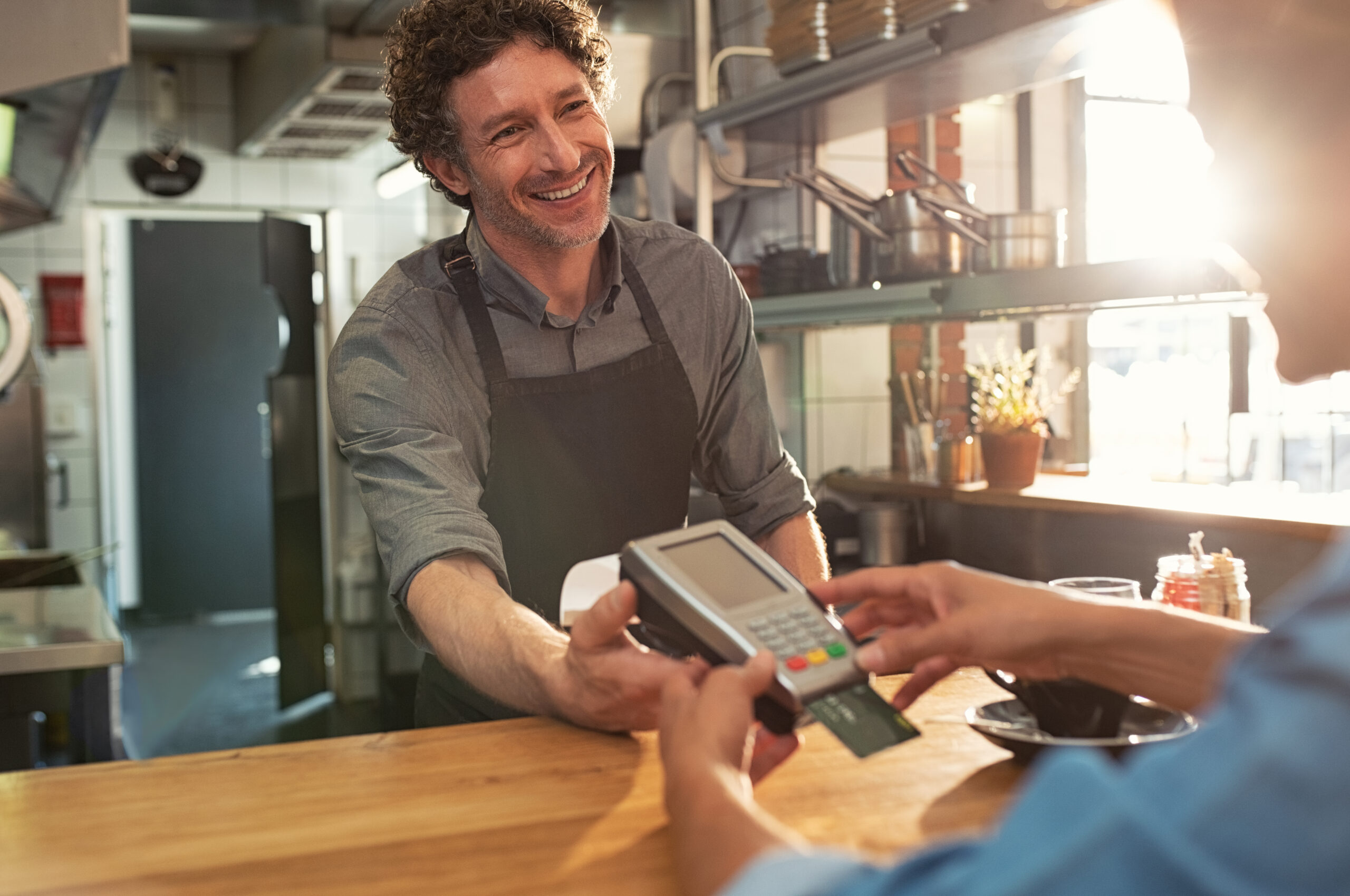 customer paying shopkeeper with credit card