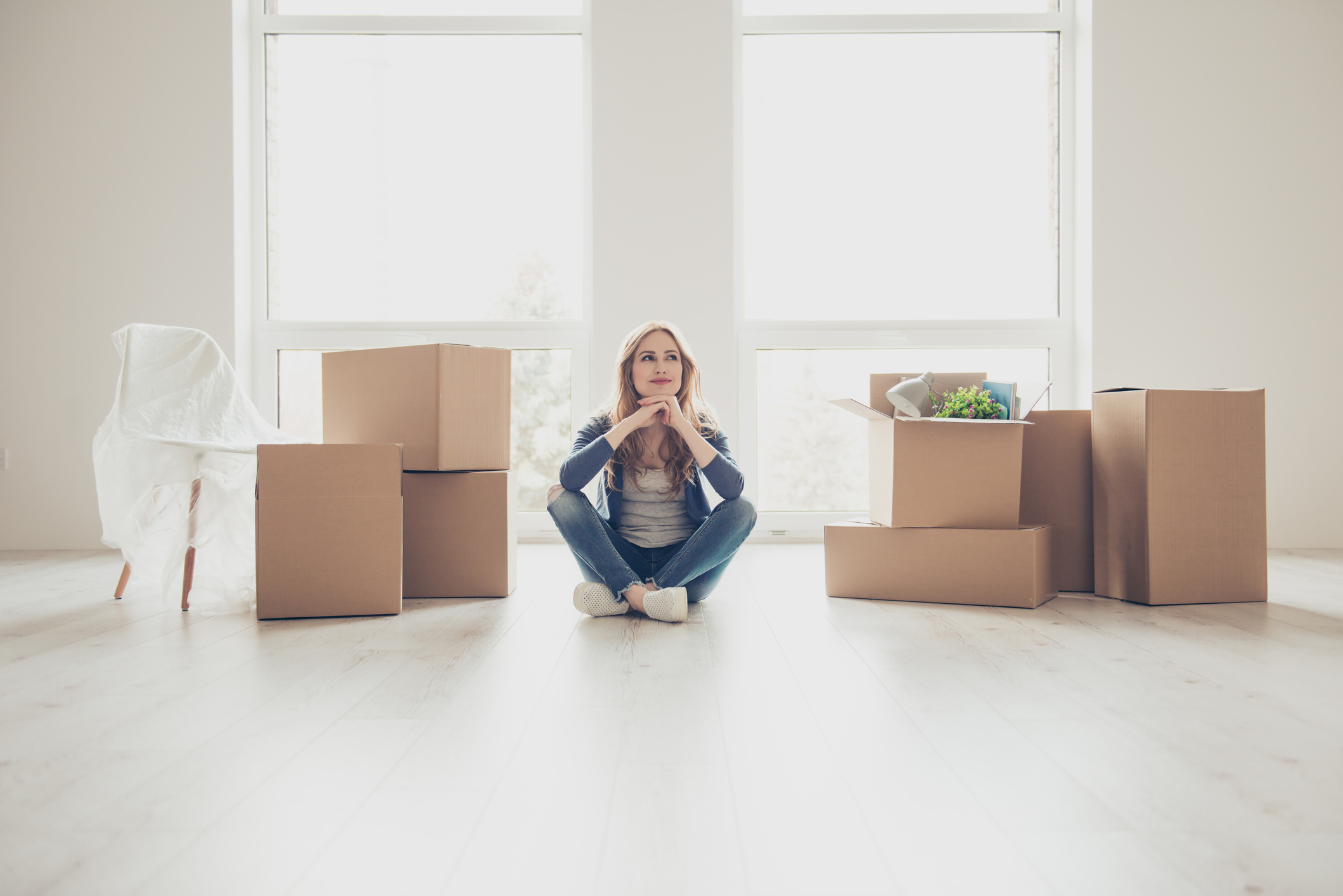 women sitting next to boxes moving
