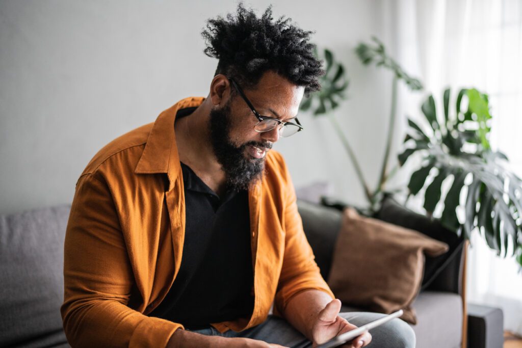 Mature man using digital tablet at home