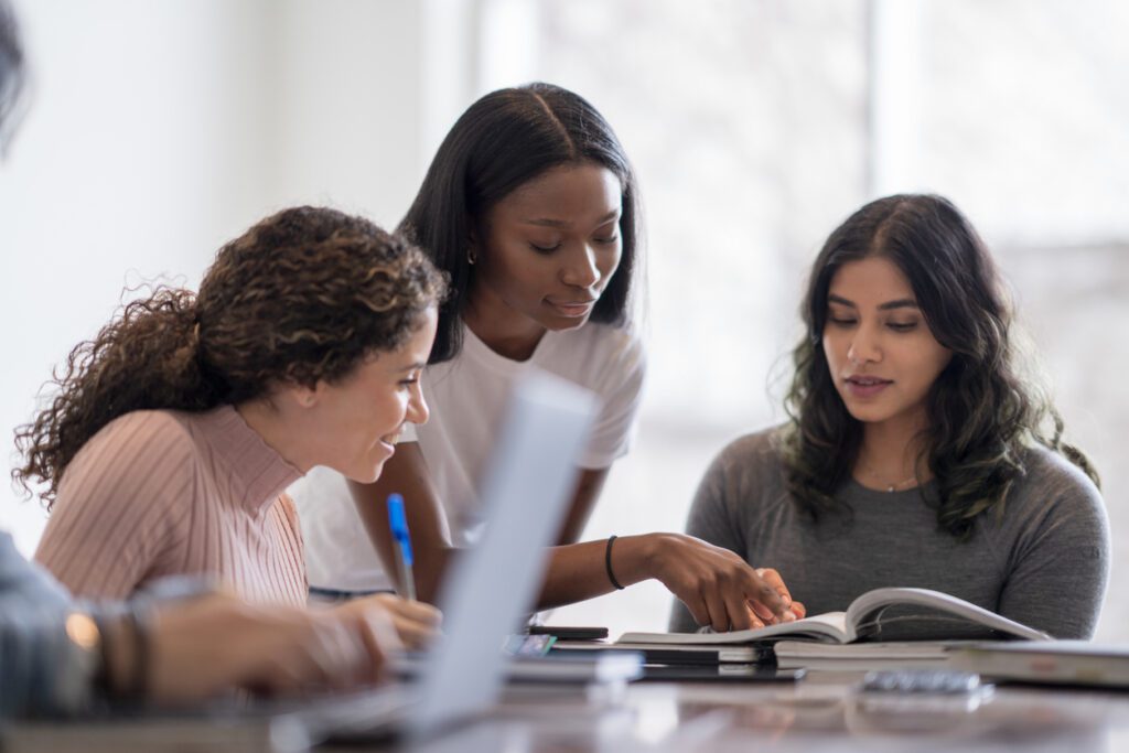 Tutor helping college students on their homework