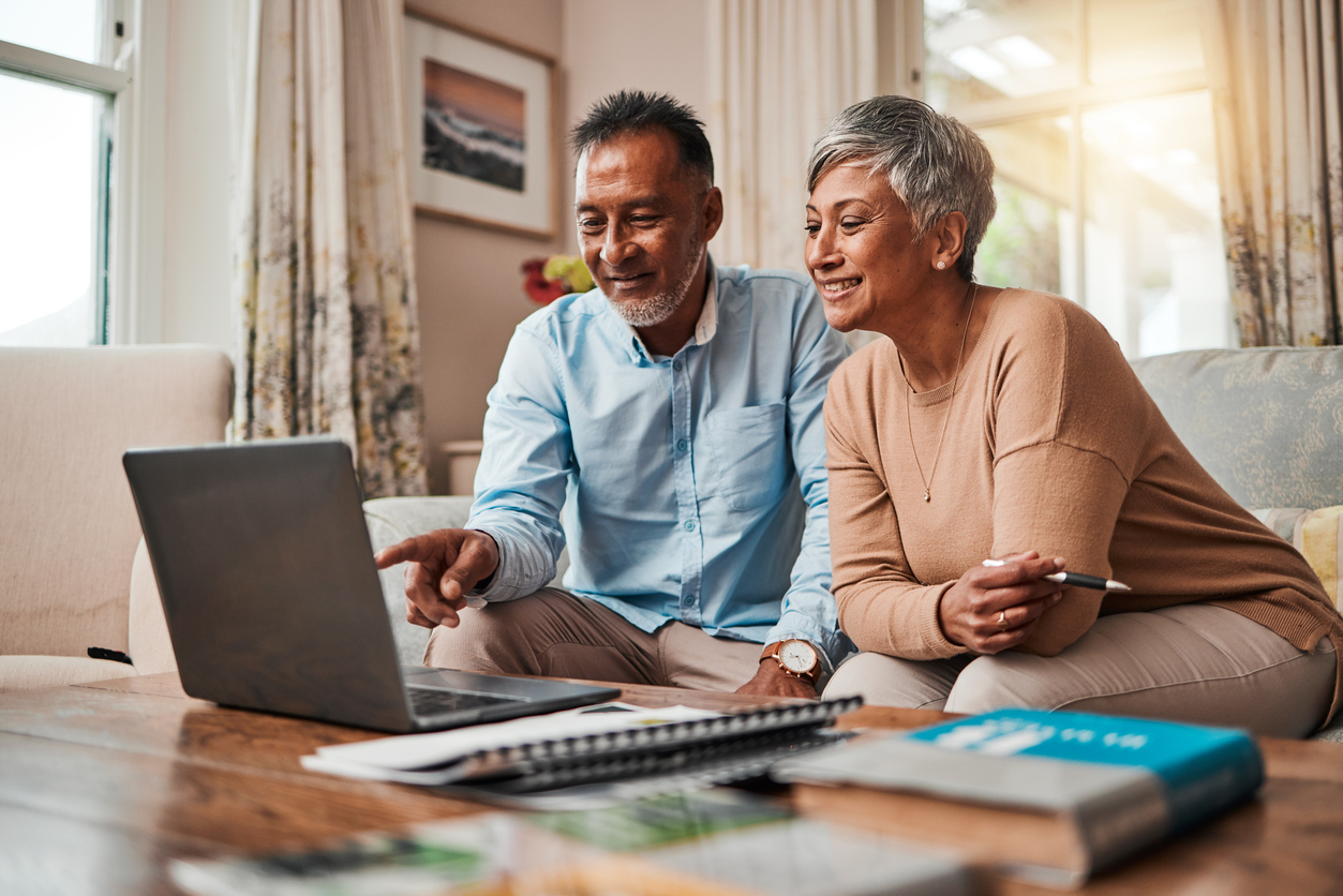 Mature couple sitting on their sofa making finance decisions deciding retirement plans and investments