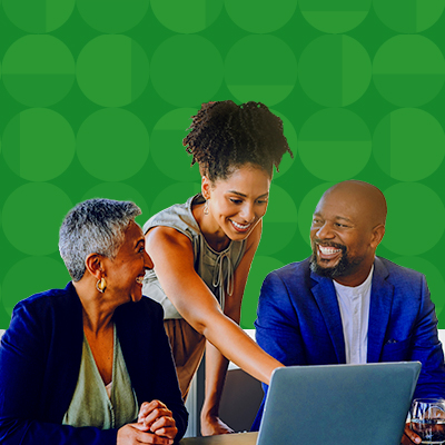 Three people having a happy meeting with one lady pointing at the laptop
