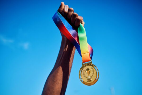 Raised hand holding a gold medal