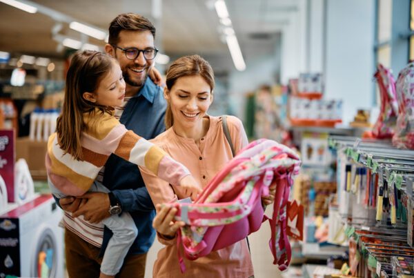 Happy family shopping for their daughter's backpack preparing for back to school