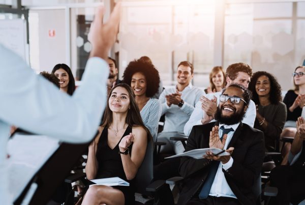People, speaker and applause at workshop in office for training, support for company conference or event. Celebrate, inclusion presentation and corporate award for team building with staff at seminar
