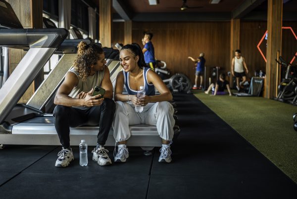 Happy couple at the gym together taking a break from their workout.