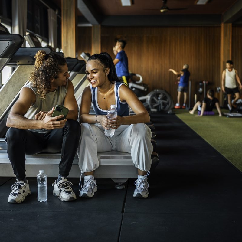 Happy couple at the gym together taking a break from their workout.