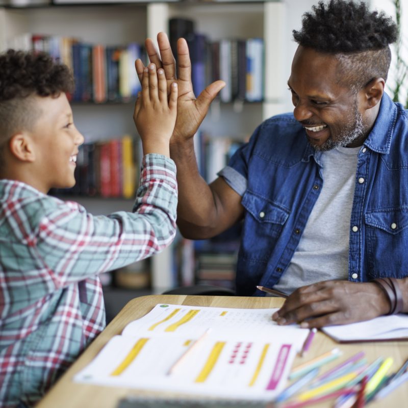 Father and son reviewing financial education pieces together.