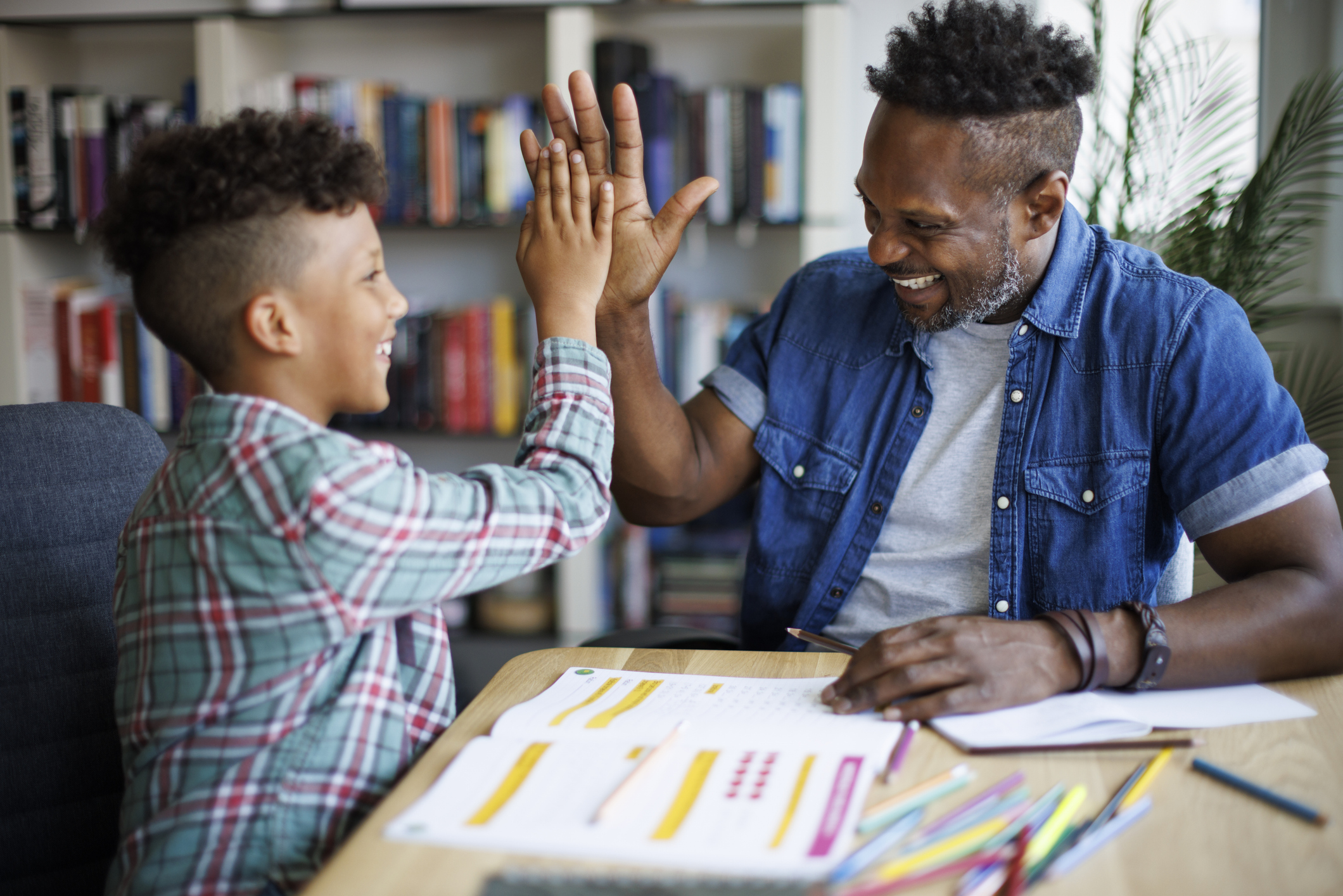 Father and son reviewing financial education pieces together.