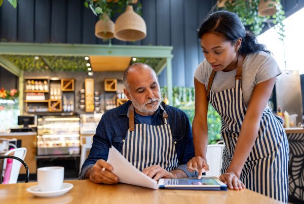 Business owner and manager using a digital tablet for accounting.