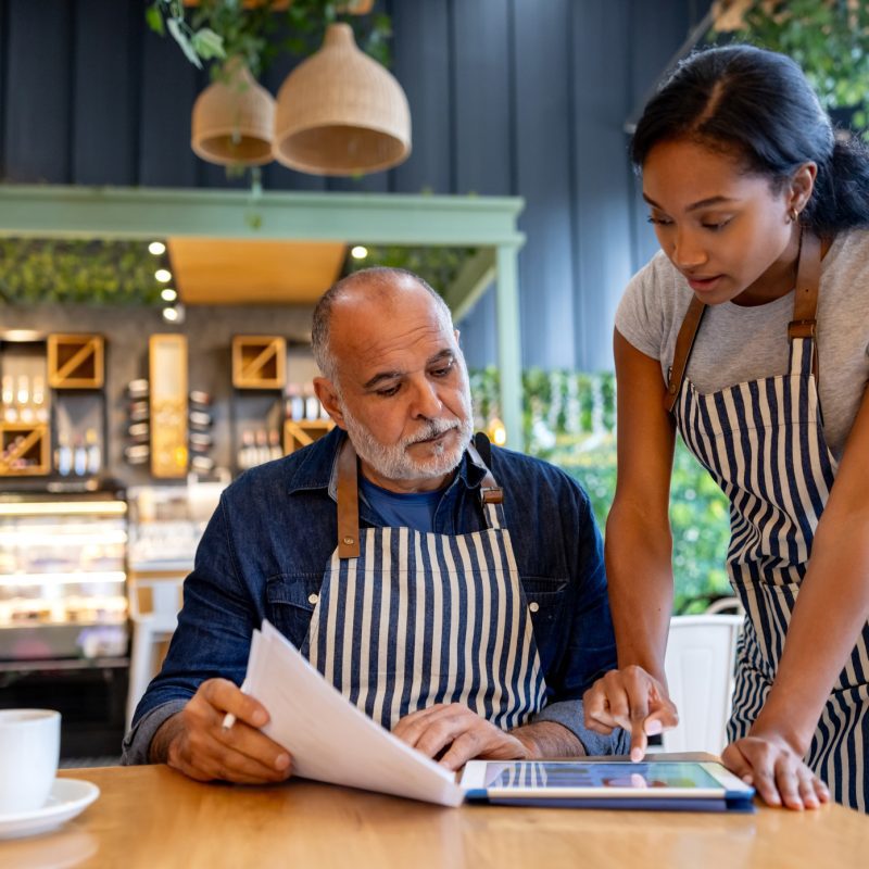 Business owner and manager using a digital tablet for accounting.