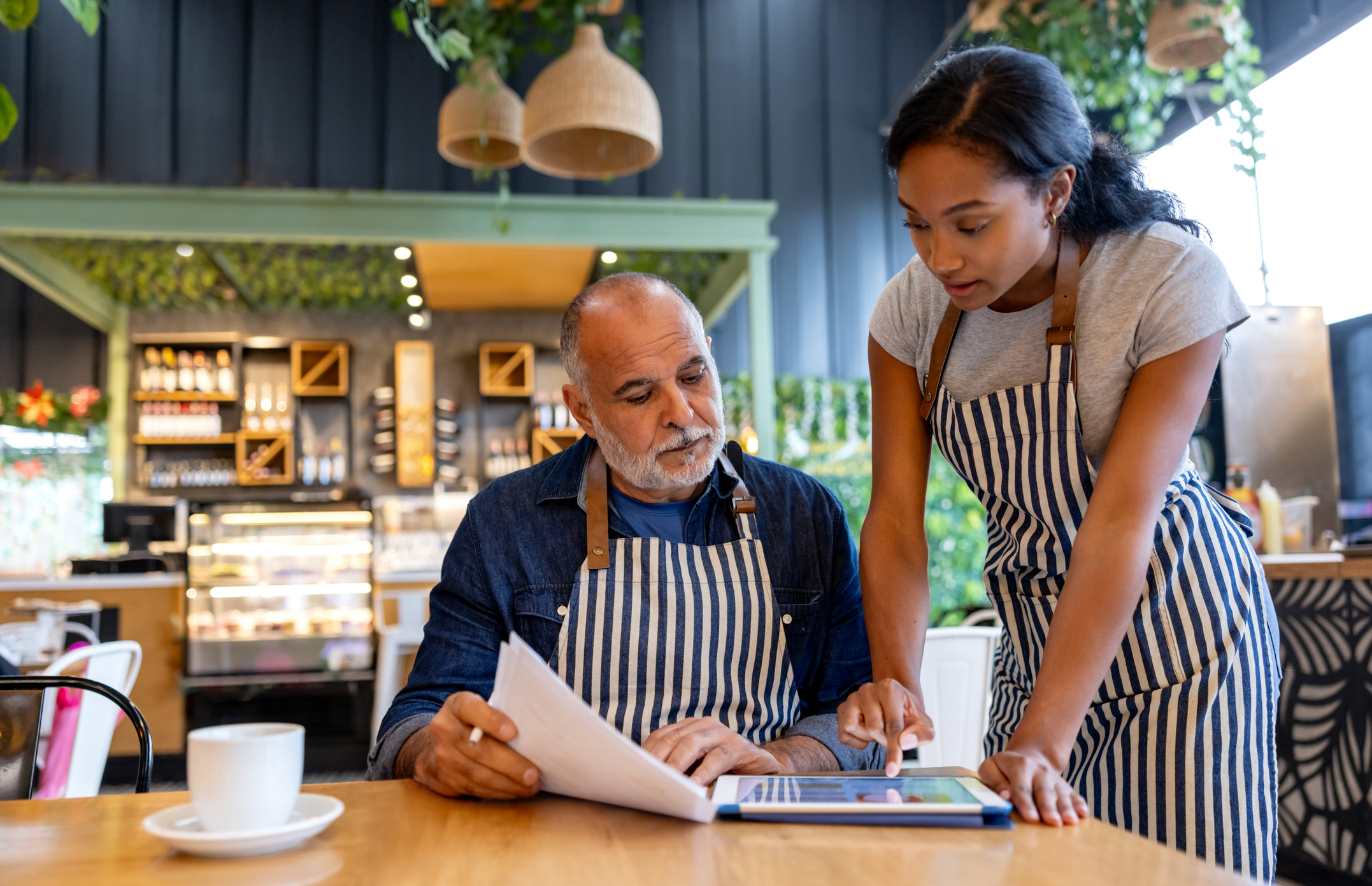 Business owner and manager using a digital tablet for accounting.