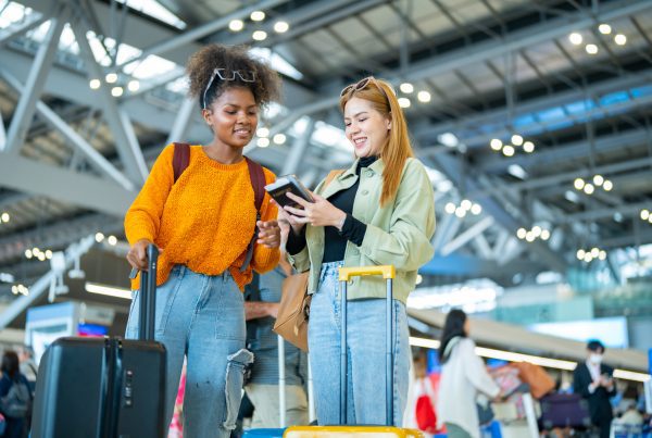 Two happy friends at the airport getting ready to board their flight