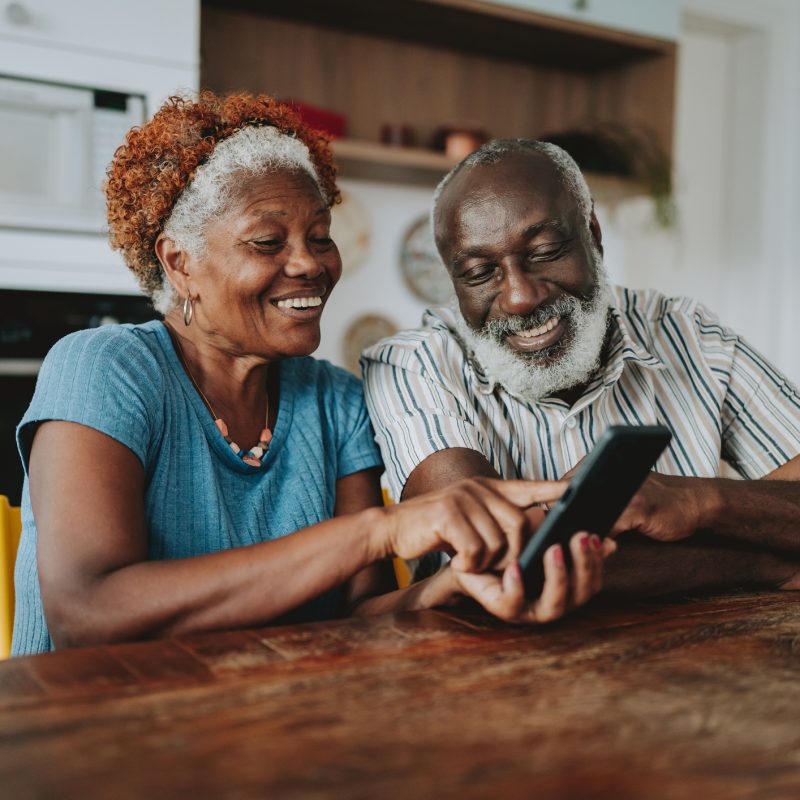 Portrait senior couple using smartphone at home
