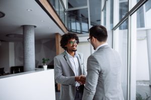 male employees shaking hands in hallway