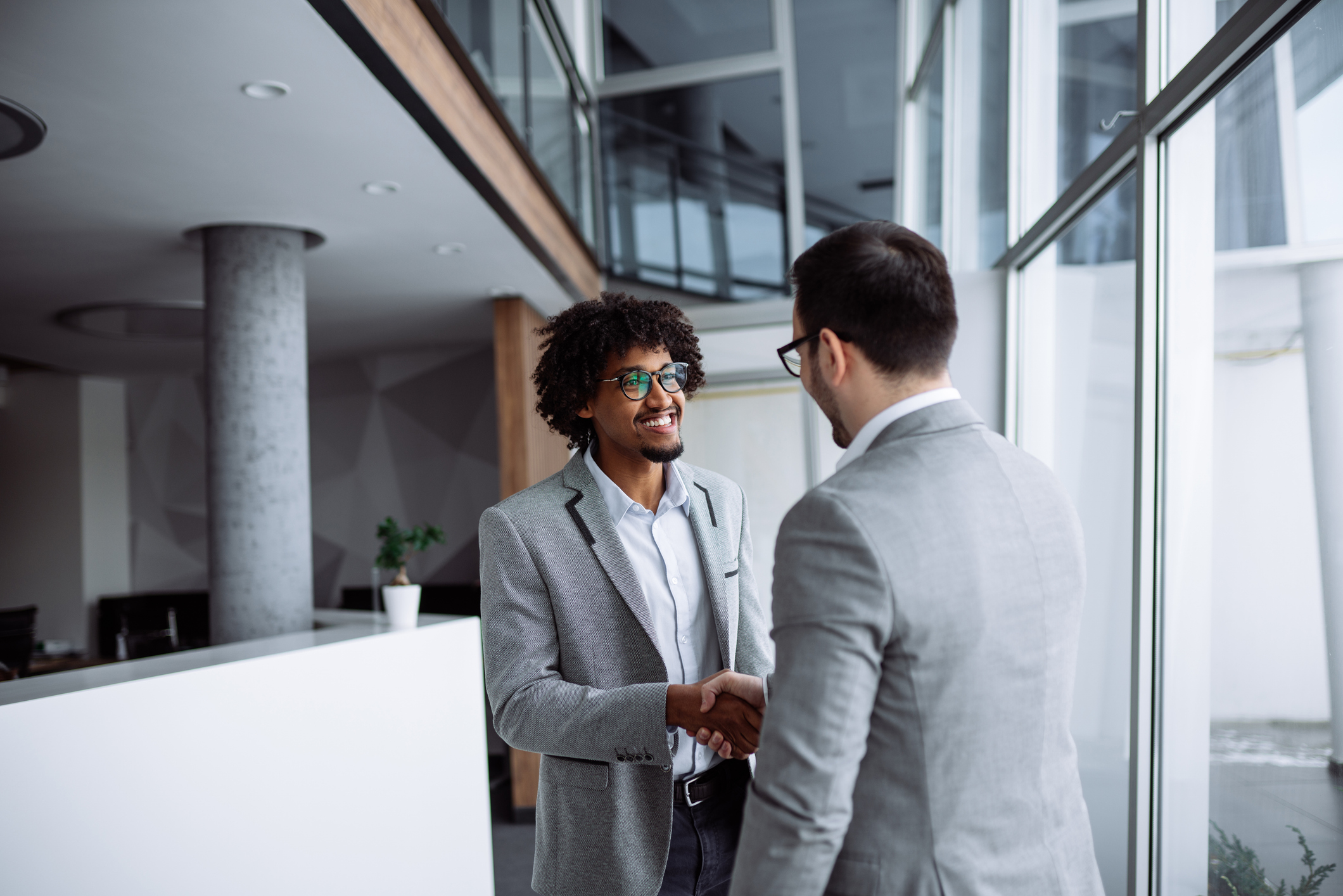 male employees shaking hands in hallway