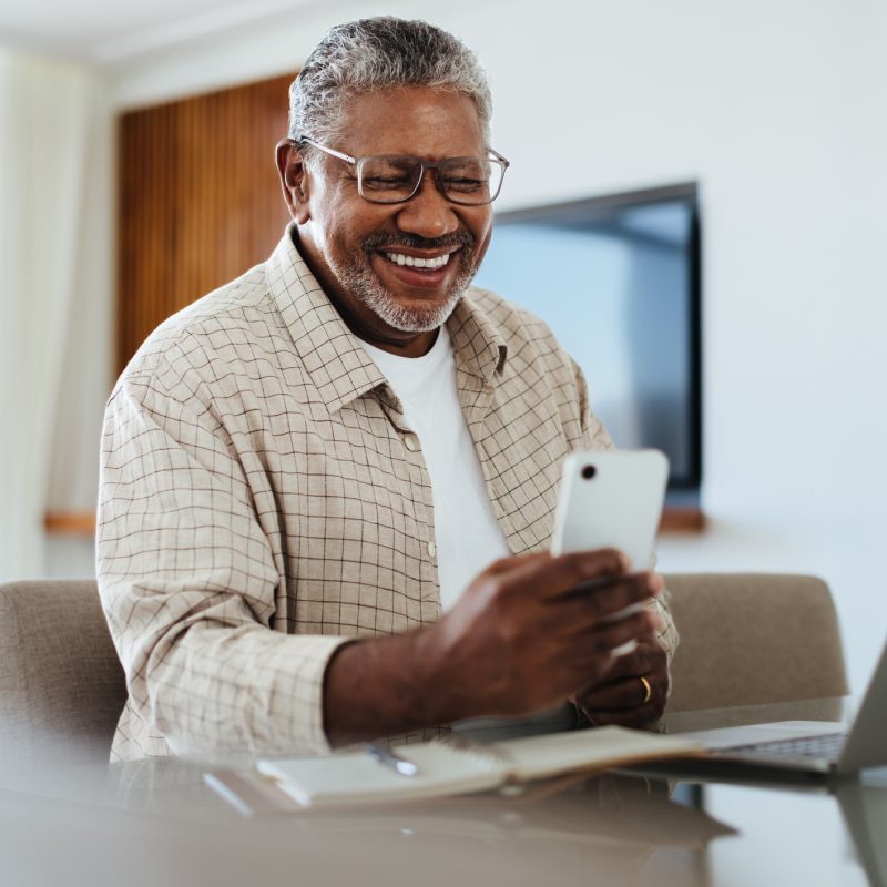 Happy male using phone for connecting and staying in touch