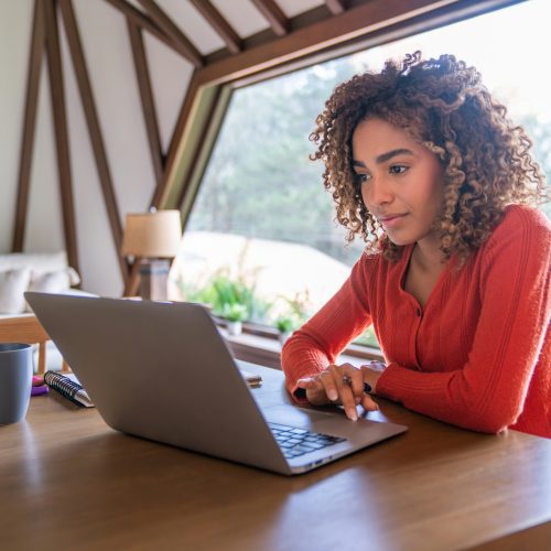 Young woman working at home using her laptop computer