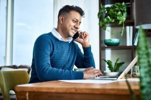 Shot of a businessman using a laptop and smartphone while working from home