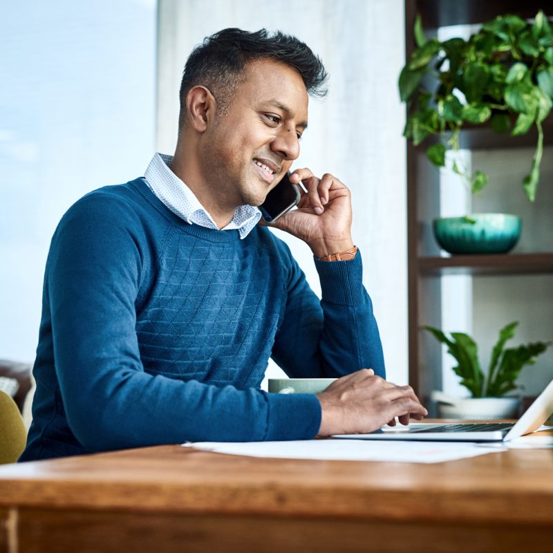 Shot of a businessman using a laptop and smartphone while working from home